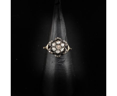 Silver on gold, set with 7 rose cut diamonds, largest diamond is approximately 3 mm. in diameter, ring size 16.5.