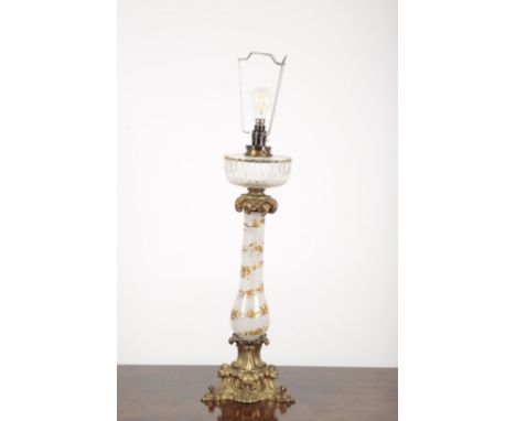 A VICTORIAN ORMOLU MOUNTED VASELINE GLASS TABLE OIL LAMP with slice cut circular reservoir, the baluster stem gilded with lea