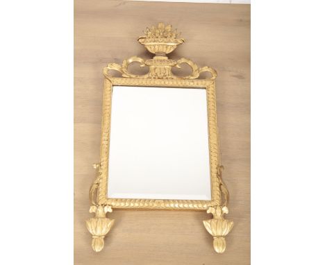 A GEORGE III STYLE CARVED GILTWOOD MIRROR the bevelled rectangular plate within a moulded surround and mounted with an urn cr