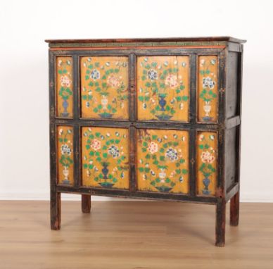 A TIBETAN PAINTED CABINET 19th century, the panelled front decorated in polychrome with vases of flowers against a yellow gro