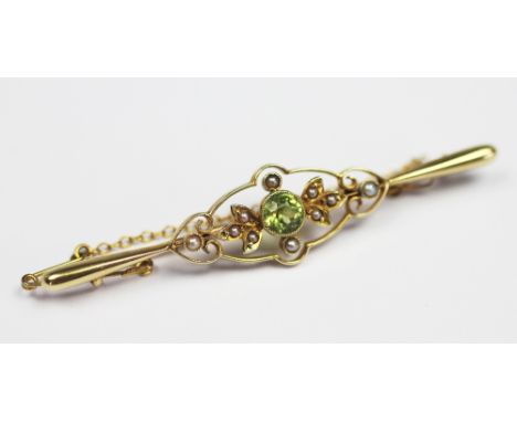 A Victorian 9ct gold, peridot and seed pearl set brook, 6cm, in Arthur Kay & Brothers Manchester box