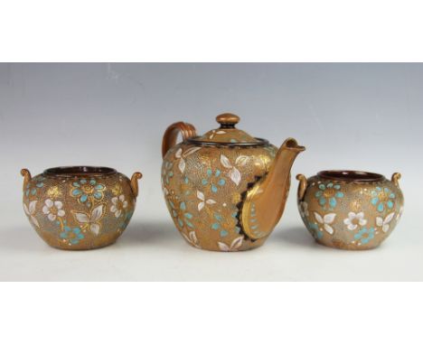 A Doulton Lambeth three piece part tea service, each highlighted in turquoise enamels and gilt, comprising; a teapot and cove