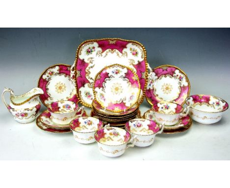 A Coalport pink batwing tea service, each piece decorated in gilt against a partially pink ground with floral decoration, com