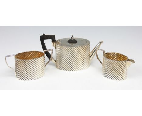 A Victorian silver three piece bachelors tea service, Hayes Brothers, Birmingham 1889, of oval form with spiral fluting and a