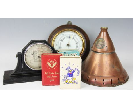 An Edwardian oak aneroid barometer, 19.5cm diameter, with a bakelite barometer, a copper dolly head, a Donald Duck book shape