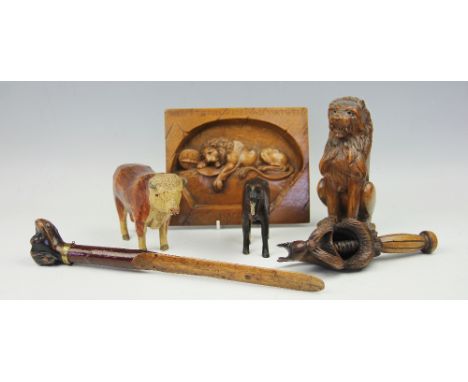 A 19th century Black Forest page turner with dogs head terminal, with glass eyes and brass collar, 31cm, a carved wood and pa