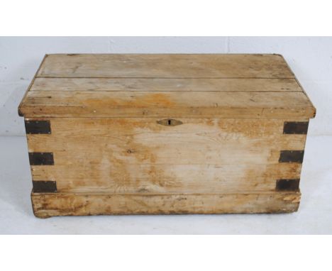 An antique rustic pine metal-bound trunk, with wrought iron handles - length 86cm, depth 45cm, height 40cm