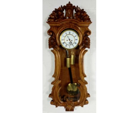 A late 19th Century carved walnut cased German wall regulator, two weight movement striking the hours and half hours on the g