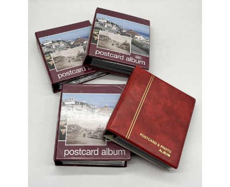 A collection of four albums of vintage postcards including a number of war themed examples