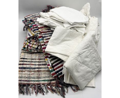 A collection of vintage linen, rag rugs etc.