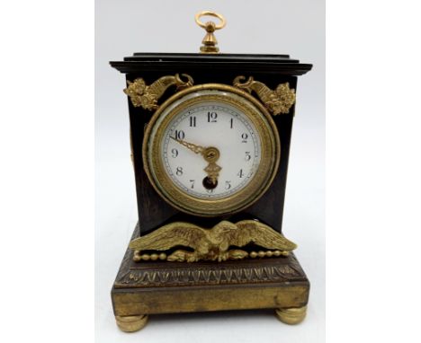A French Empire style metal cased mantle clock with brass detail, 11cm wide, 18cm high.