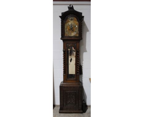 An antique heavily carved oak longcase clock, marked 'Festina Lente', with bevelled glass door and barley-twist detailing - l