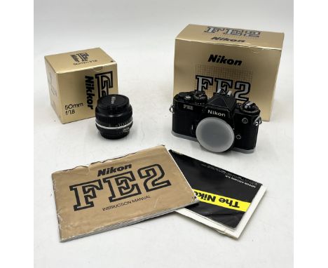 A Nikon FE2 SLR Body in black along with a Nikkor 50mm lens, both in original boxes with packaging and instruction manual for