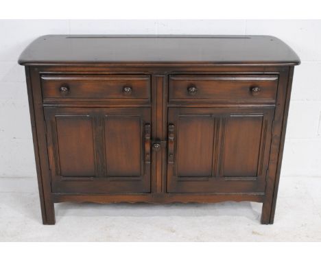 An Ercol sideboard, with two drawers and cupboards under - length 123cm, depth 48cm, height 84.5cm