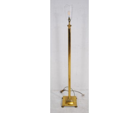 An antique style brass column standard lamp, with claw feet