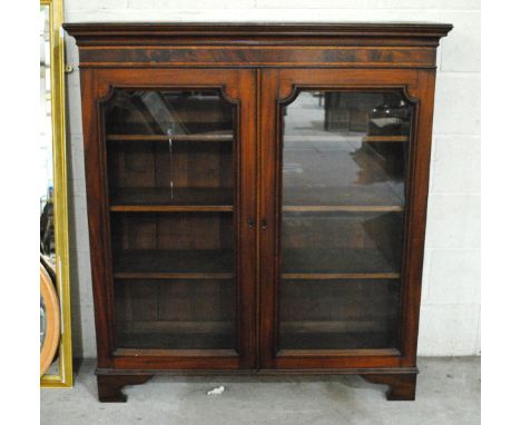 An antique mahogany glazed bookcase, raised on bracket feet - length 122cm, depth 36cm, height 134cm