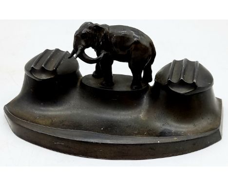 An Art Deco spelter inkwell mounted with central elephant, 20cm wide, 11cm deep, 8cm high, (missing inkwells).