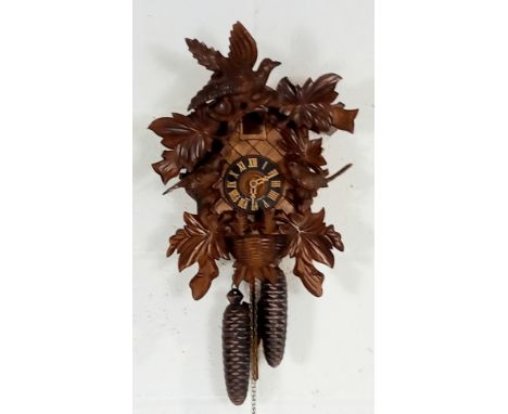 A German Black Forest carved wood cuckoo wall clock with applied and carved foliage and birds, 40cm length.