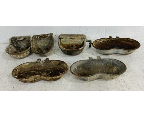 A collection of six vintage cast iron small animal feeder troughs 