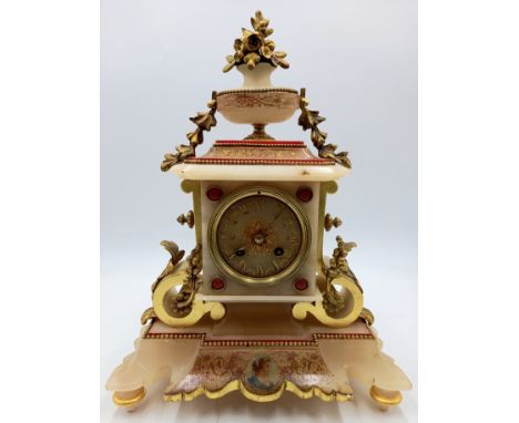 A French alabaster mantle clock with gilt metal mounts, with transfer decoration to the face and base, 30cm wide, 39cm high. 