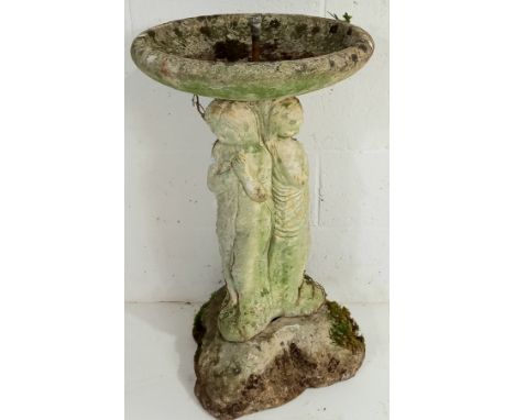 A vintage concrete garden water fountain of the three graces.