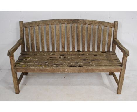A weathered wooden garden bench - length 150cm