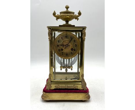 A19th century four-glass French gilt bronze mantle clock with urn finial and on gilt velvet stand, movement stamped for AD. M