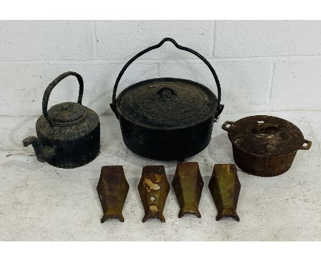 A vintage cast iron lidded cauldron along with a cast iron kettle, saucepan and four feet