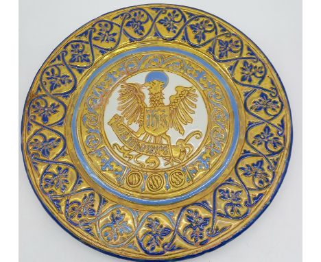 A vintage pottery tin glazed decorated charger, with central eagle motif, 44cm diameter.