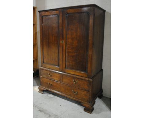 A Georgian oak linen press, with three drawers, raised on bracket feet, with wooden castors - one loose but present - with ke