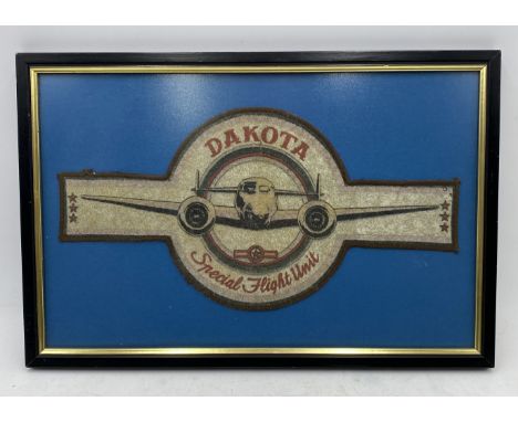 A framed vintage Dakota Special Flight Unit patch for the Berlin Airlift, used on the back of a "bomber jacket", width of pat