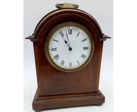 An Edwardian mahogany and string inlay mantle clock with French movement, on brass bun feet, 22cm high.