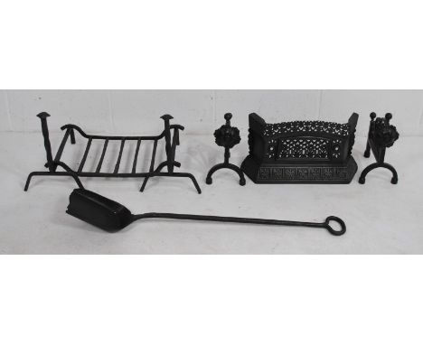 A pair of cast iron fire dogs with grate, fire guard, shovel etc.