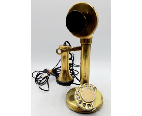 A vintage brass candlestick telephone.