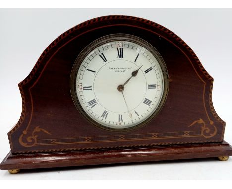 An Edwardian mahogany and inlaid mantle clock by Schama O'Neill Belfast, on brass bun feet, 16cm high.