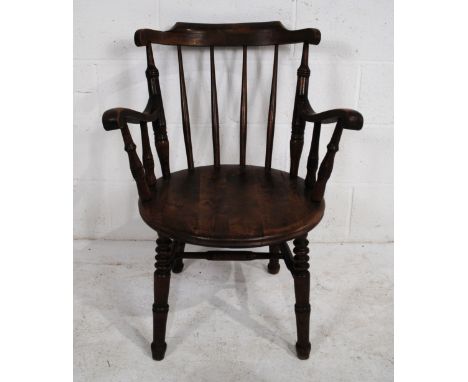 An antique stick-back armchair with turned detailing