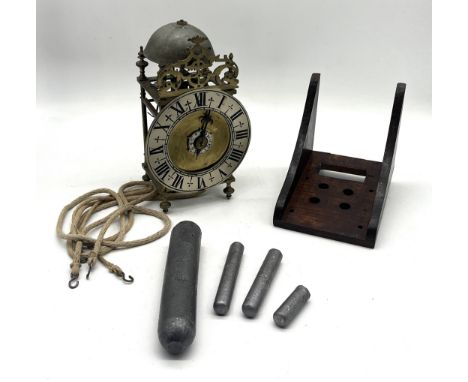 An antique brass lantern clock, possible French, with set of four weights, roman numeral silvered dial and wooden wall bracke