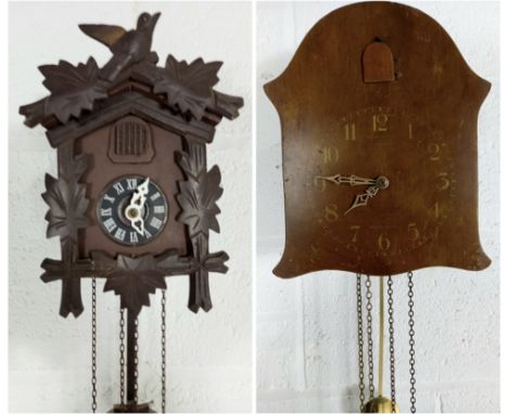 A vintage oak cased cuckoo clock, and another with carved decoration.