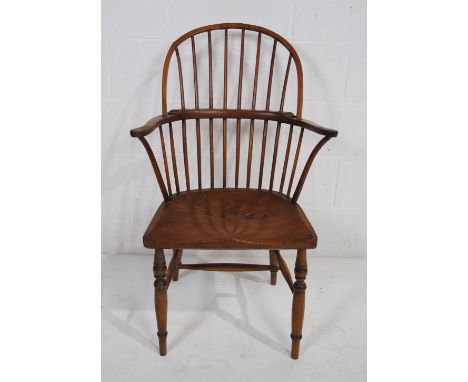 An antique elm Windsor stick-back chair, raised on turned legs - some repairs as shown