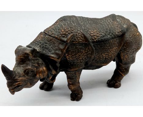 A vintage cast metal inkwell in the form of a Rhino with bronze coloured patination, (Missing ears) 20cm length, 12cm high.