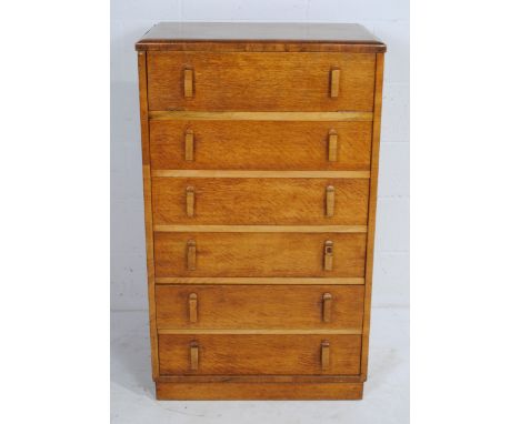 A vintage oak dressing chest of five drawers by Herbert E. Gibbs, with lift up top revealing rectangular mirror and two small