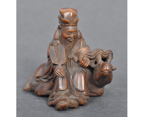 A fine Japanese believed Edo period / 19th century carved wooden signed netsuke. The netsuke in the form of an elder alongsid