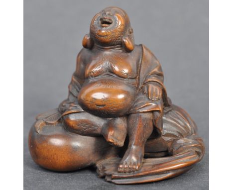 A fine Japanese believed Edo period / 19th century carved wooden signed netsuke. The netsuke in the form of Hotei, atop his N