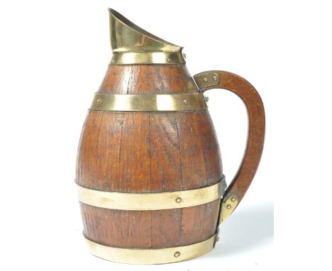 An early 19th Century antique wooden treen pitcher jug of coopered barrel form. Oak construction with brass bound and pinned 