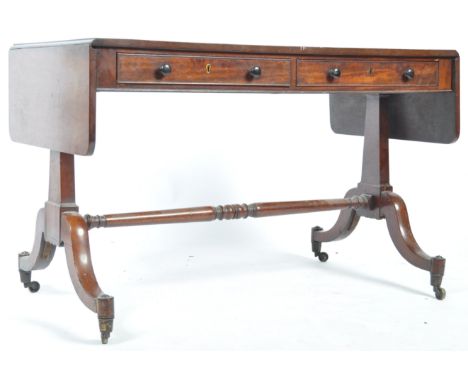 An early 19th Century Georgian Regency period English antique mahogany sofa table having a pair of drawers to the frieze with