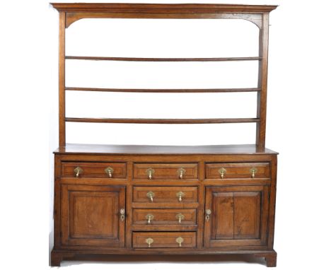 An 18th Century English antique country house oak kitchen dresser base and top having a multiple tier delft / plate rack top 