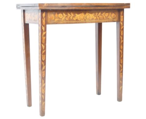 A 19th Century English antique Dutch marquetry inlaid card table / games table having an inlaid top decorated with scrolls an