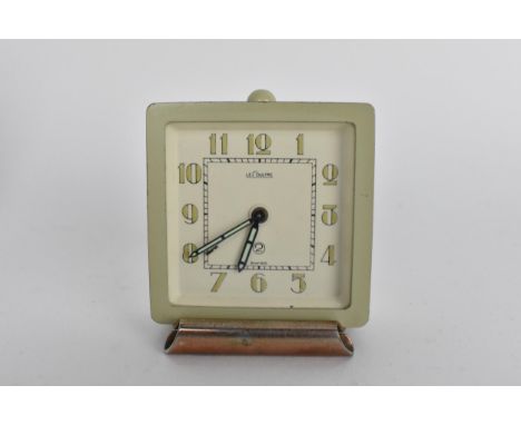 An Art Deco LeCoutre bedside travel/desk alarm clock in a metal case, the dial having Arabic numerals with luminous hands and