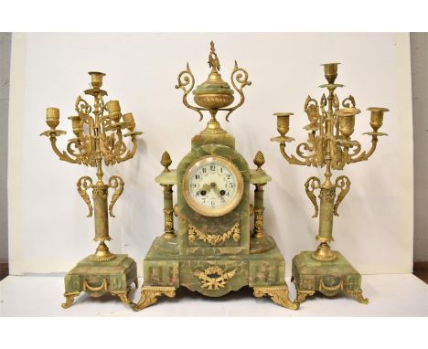 A late 19th century French onyx and gilt metal mantle clock with two matching garnitures. The clock having an urn shaped fini