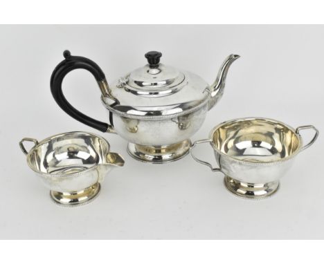 A 1930s silver three piece tea service, Birmingham 1931 by A L Davenport Ltd, comprising of a black handled teapot, a sugar b